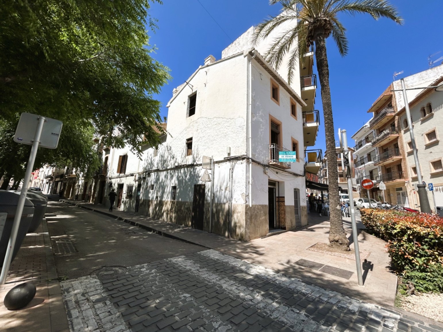 Exterior corner view of the three-story townhouse in Jávea's historic center, featuring a traditional white facade and classic wooden shutters.