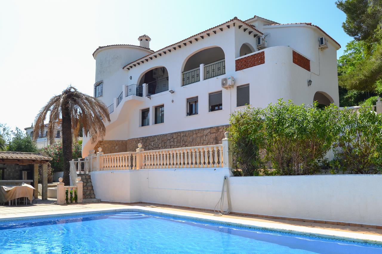 Exterior view featuring the 12x6m swimming pool, arched Mediterranean terraces, and a traditional white facade with natural stone accents.