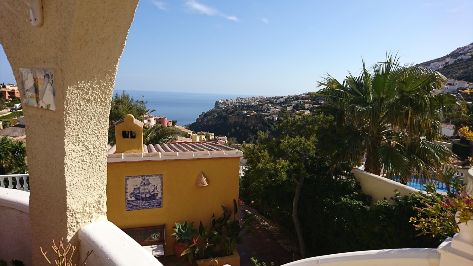 Panoramic Mediterranean Sea views from the terrace, framed by traditional arches and overlooking lush gardens with authentic ceramic details.