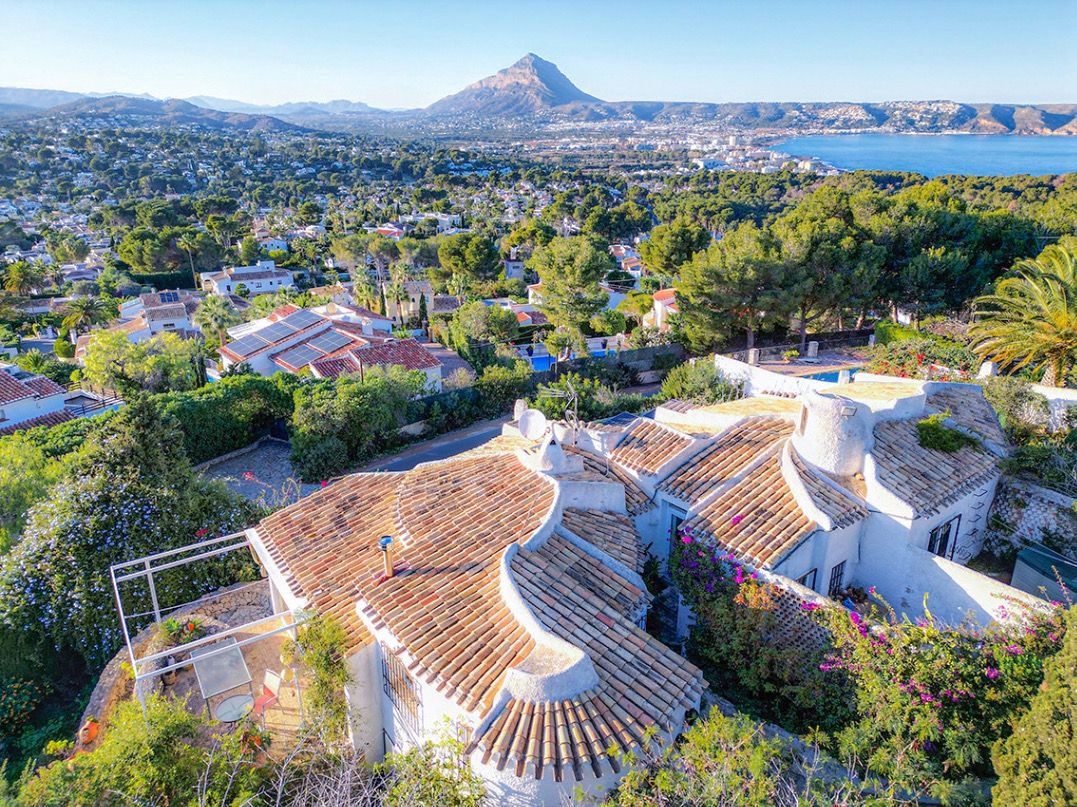 Aerial view of the traditional villa's terracotta roofs, showcasing panoramic vistas of the Jávea coastline and the iconic Montgó mountain.
