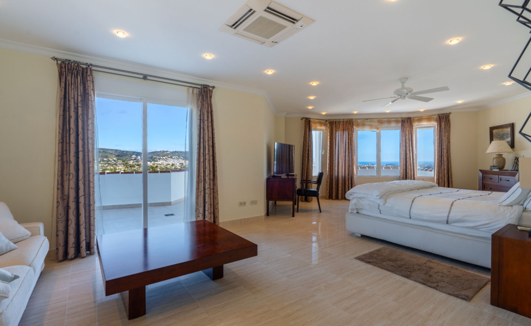 Master bedroom featuring private terrace access, polished tile flooring, integrated climate control, and panoramic views of the coast and mountains.