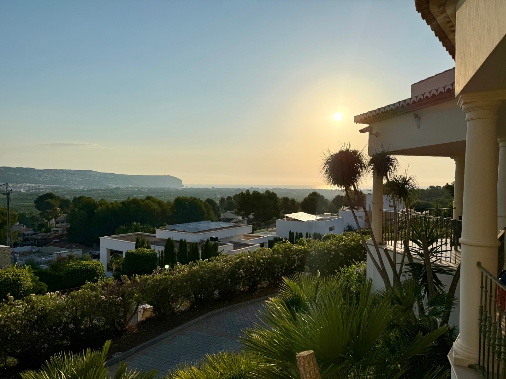 Panoramic view from the upper terrace towards the Mediterranean at sunset, featuring classical columns and the landscaped surroundings of the Piver urbanization.
