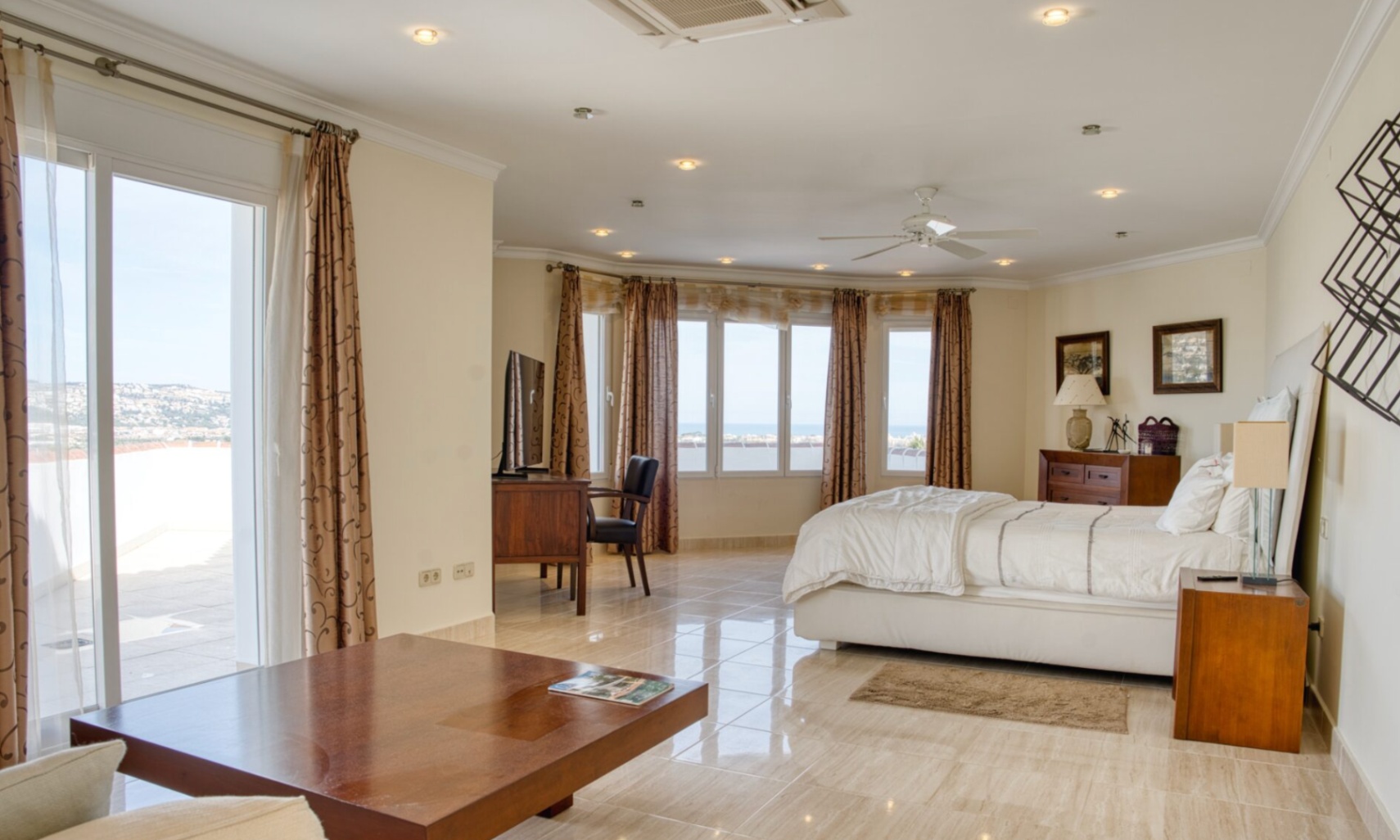 Spacious master suite featuring marble flooring, a dedicated workspace, and large windows with sea views. Includes direct access to the terrace and recessed lighting.